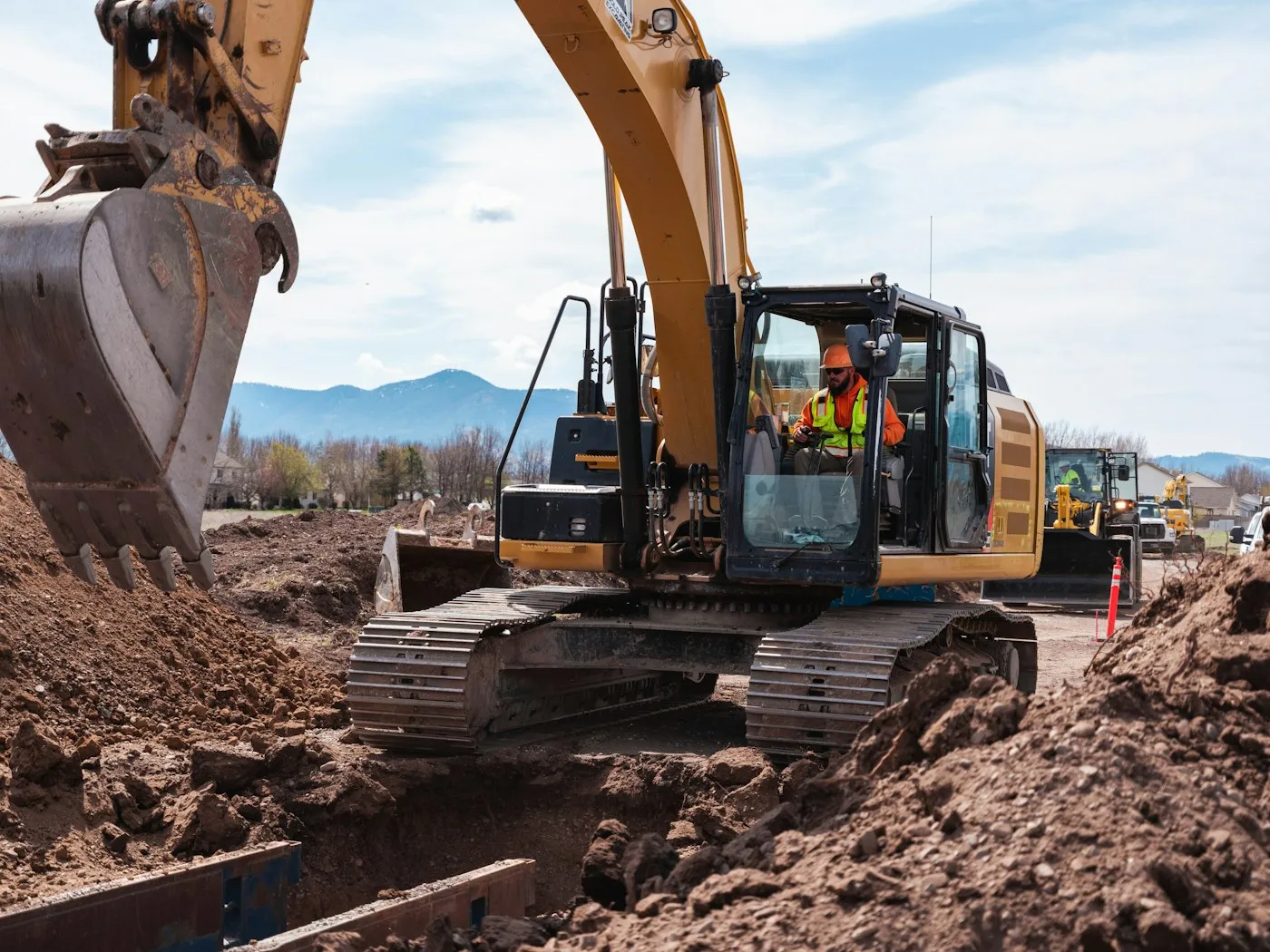 Excavator bucket and tracks on a dirt site